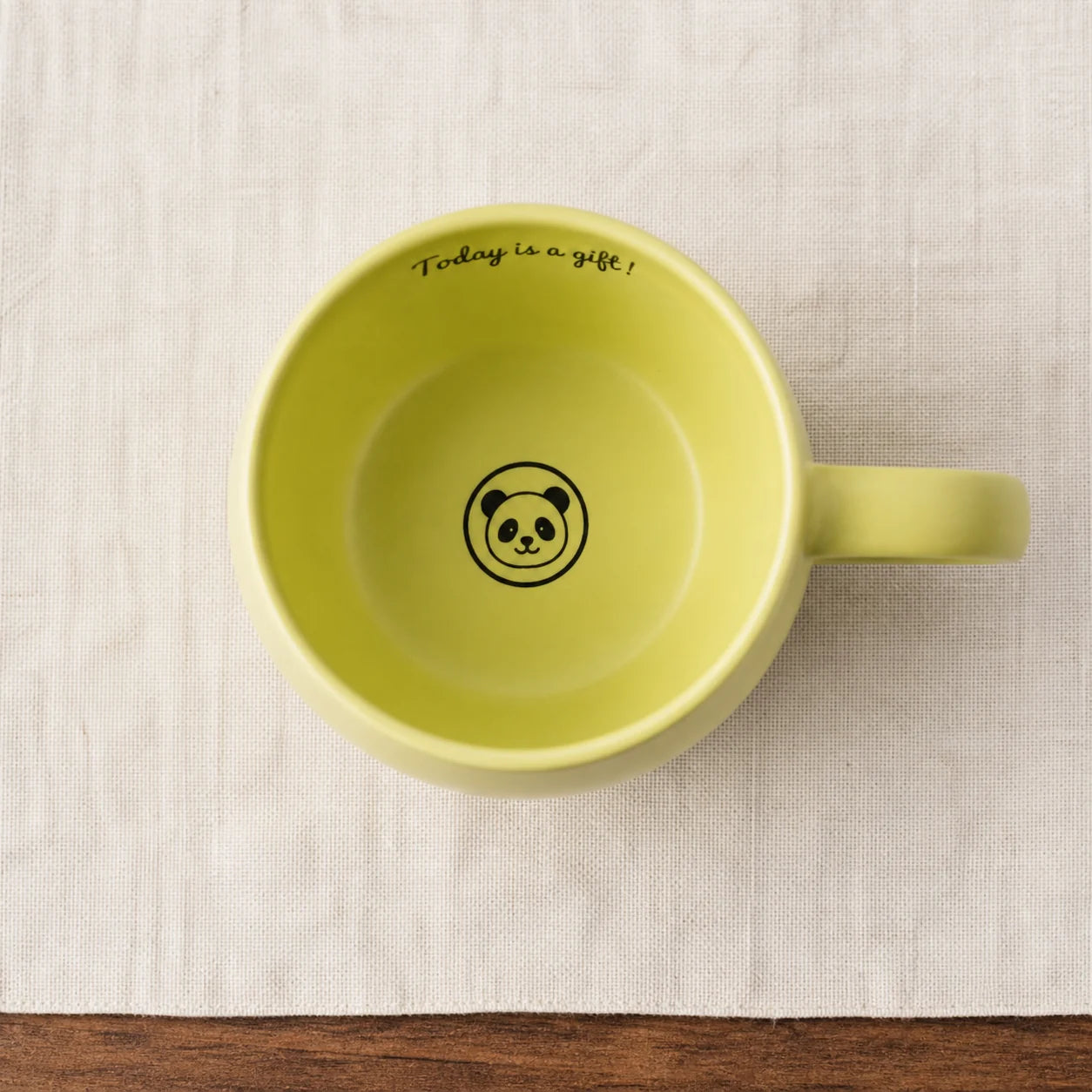 Panda illustration revealed at the bottom of the empty green ceramic mug